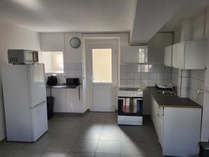 una cucina con elettrodomestici bianchi e frigorifero bianco di Appartement en duplex a Évry-les-Châteaux