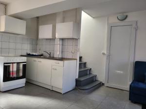 una cucina con armadi bianchi e una scala con porta di Appartement en duplex a Évry-les-Châteaux