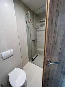 a bathroom with a shower and a toilet and a door at Platán Garden közvetlen vízparti apartman in Balatonboglár