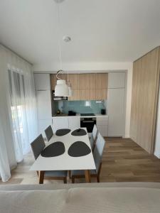 a kitchen with a table and chairs in a room at Platán Garden közvetlen vízparti apartman in Balatonboglár