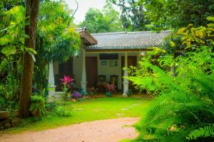 une petite maison au milieu d'un jardin dans l'établissement Travelodge Sigiriya, à Sigirîya
