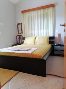 um quarto com uma cama grande e uma janela em Homey Family ArtAki em Néa Artáki