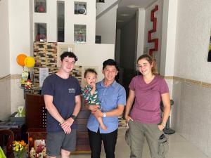 un grupo de tres personas posando para una foto en Huy Hoàng Motel - Cần Thơ, en Can Tho