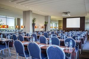 a conference room with tables and chairs and a screen at Centro Sharjah in Sharjah +34 photos