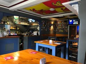 um bar com mesas de madeira num restaurante em The Slaters Arms Corris em Machynlleth