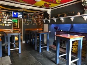 a row of stools in a bar with a fireplace at The Slaters Arms Corris in Machynlleth