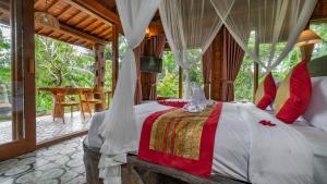 a bedroom with a bed with a canopy at Iyume Villas in Tegalalang +37 photos