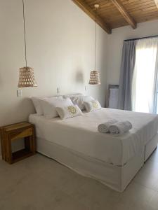 a bedroom with a large white bed with two pendant lights at Posada Miss Olivos in San Rafael
