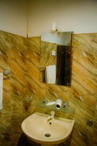 een badkamer met een wastafel en een spiegel bij Travelodge Sigiriya in Sigiriya