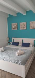 a bedroom with a large bed with blue walls at Duomo Rooms Cefalù in Cefalù