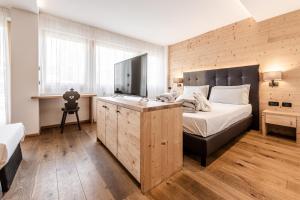 a bedroom with a large bed with a wooden wall at Ravelli Sporting in Mezzana