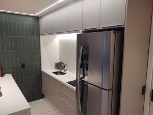 cocina con nevera de acero inoxidable y fregadero en apartamento 5 estrelas bela vista, en São Paulo