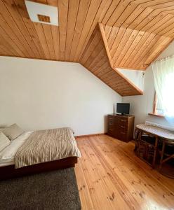 a bedroom with a bed and a wooden ceiling at Ošupynė in Šventoji