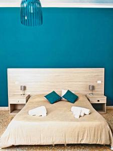 1 dormitorio con 1 cama grande y pared azul en Il Quadrifoglio Room& Suite, en Palermo