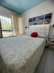 Un dormitorio con una cama grande con una almohada roja. en Mi Sueño en San Antonio de Arredondo