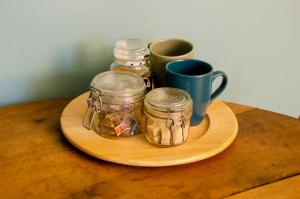 a wooden plate with jars and cups on a table at Au 41 - le calme à 5 min d'Auxerre in Saint-Georges-sur-Baulche