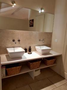 a bathroom with two sinks and a mirror at Gîte Douceur de Provence in Maubec
