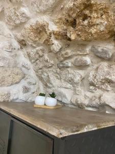 dos jarrones blancos sentados en una mesa frente a una pared de piedra en House71043, en Manfredonia