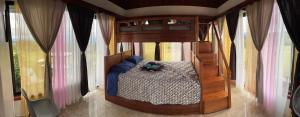 a bedroom with a canopy bed in a room with windows at Las Pavitas Arenal Suites in Fortuna +102 photos
