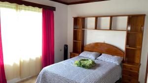 a bedroom with a bed with a wooden head board at Las Pavitas Cottages in Fortuna