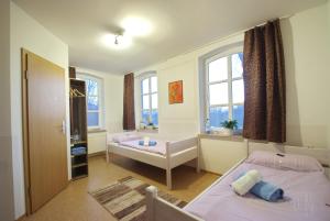 1 Schlafzimmer mit 2 Betten und 2 Fenstern in der Unterkunft Gasthuus Ulenhoff in Westoverledingen