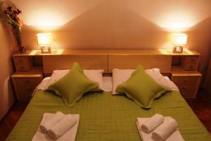 a bedroom with a bed with pillows and two lamps at Apartments Stari Šibenik in Grebaštica