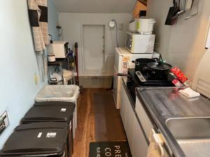 a small kitchen with a stove and a microwave at 自遊人の宿 in Odawara