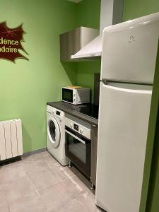 a kitchen with a refrigerator and a washing machine at Jacquemart in Moulins