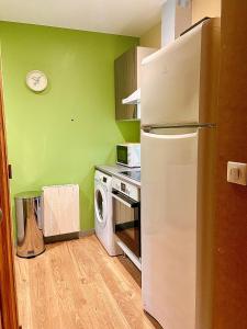 uma cozinha com um frigorífico branco e um micro-ondas em Jacquemart em Moulins
