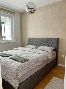 een slaapkamer met een bed met een grijs hoofdeinde en een raam bij Apartment TT Jahorina in Jahorina