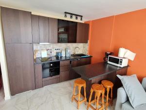 uma cozinha com um balcão e bancos num quarto em Cozy apartment very close to Yumbo Center em Playa del Inglés