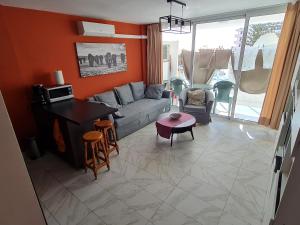 uma sala de estar com um sofá e uma mesa em Cozy apartment very close to Yumbo Center em Playa del Inglés