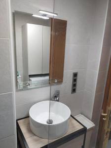 uma casa de banho com um lavatório branco e um espelho. em Cozy apartment very close to Yumbo Center em Playa del Inglés