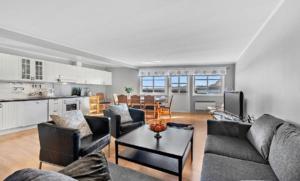 a living room with couches and a table and a kitchen at Lofoten Sunset & Ocean VIew in Valle