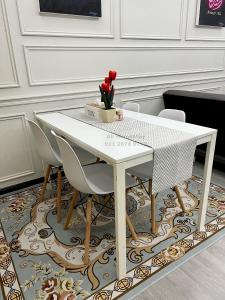 a white table and chairs on a rug at Ali Homestay Sungai Petani in Sungai Petani