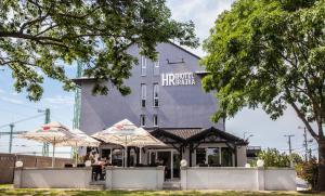 um edifício com dois guarda-chuvas à frente em Hotel Rajka em Rajka