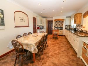 a dining room with a table and chairs in a kitchen at Rhiangwyn in Holyhead
