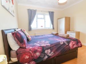 霍利黑德的住宿－Rhiangwyn，一间卧室配有一张带花卉床罩的大床