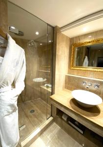 La salle de bains est pourvue d'un lavabo et d'une douche en verre. dans l'établissement Chateau Eza, à Èze