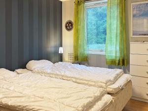 Holiday home SVANESUND IV في Svanesund: سرير غير مرتب في غرفة نوم مع نافذة