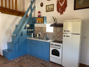 a blue kitchen with a sink and a refrigerator at Konstantino's Place in Samos