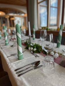 uma mesa com velas verdes e brancas e copos de vinho em Panoramahotel Grobauer em Spiegelau