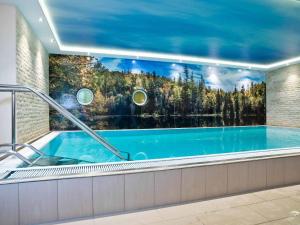 a swimming pool in a house with a large window at Panoramahotel Grobauer in Spiegelau