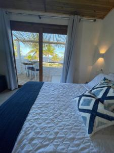 1 dormitorio con 1 cama y vistas a la playa en Aldeia Coqueiral, en Caraíva