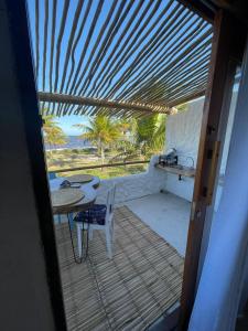 a table and a chair on a porch with a view of the ocean at Aldeia Coqueiral in Caraíva