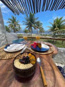 a wooden table with a plate of food on it at Aldeia Coqueiral in Caraíva