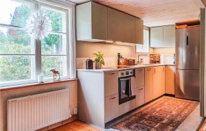 eine Küche mit Küchengeräten aus Edelstahl und einem großen Fenster in der Unterkunft 3 Bedroom Awesome Home In Vstervik in Västervik