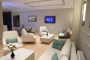 a living room with white furniture and a tv at Turkuaz Hotel in Gebze