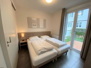 a bed in a room with a large window at Triton suite Duinhof - Stijn Albrechtsstraat 1-6 in Cadzand