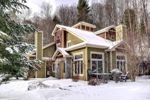 a house with snow on the ground in front of it at Excellent Townhome On Golf Course w/3 Bdrm 2 Bath in Mont-Tremblant